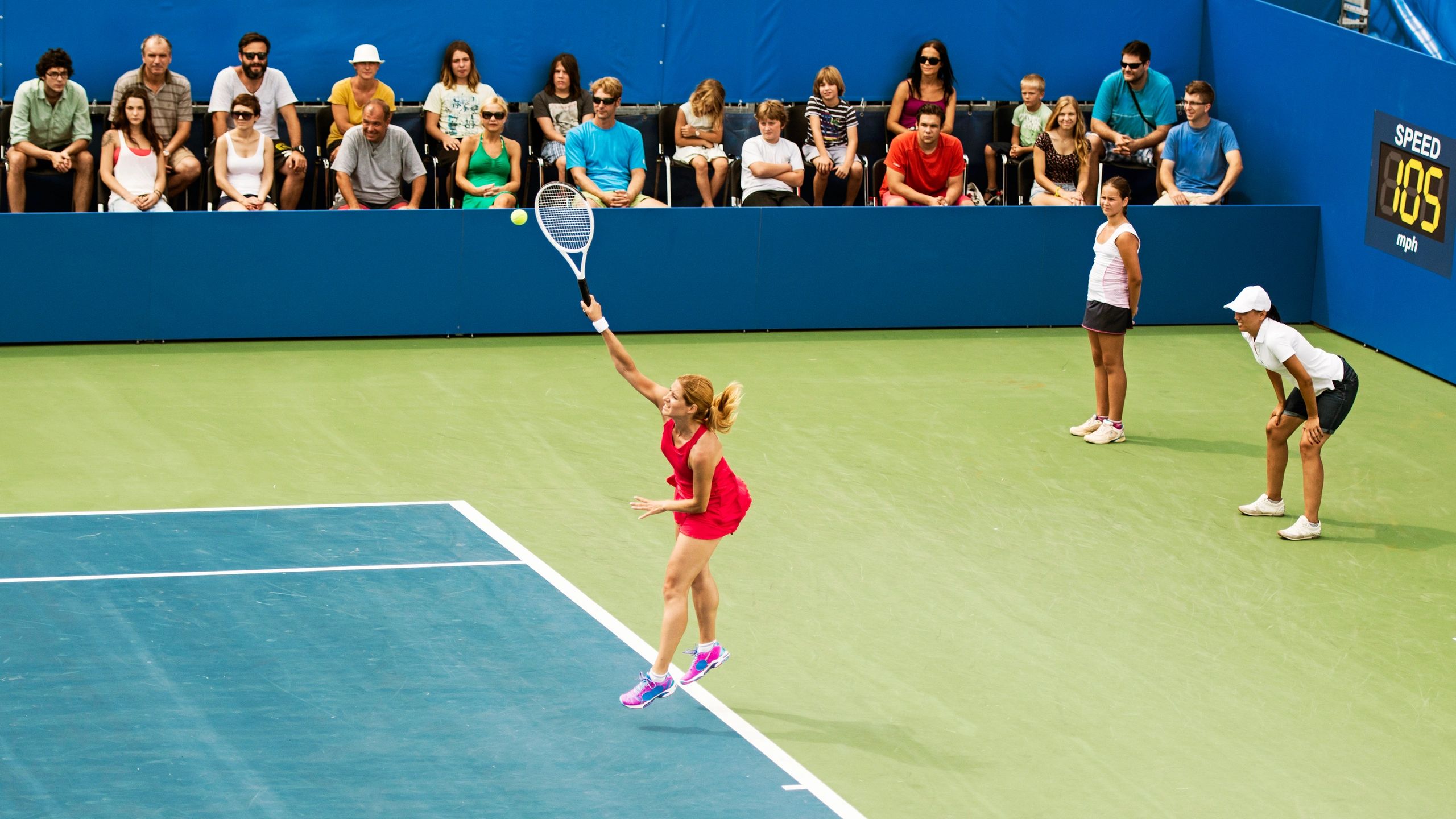 Tennis player serving in a stadium